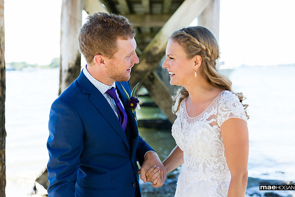 Bride and groom under Peaks Island Pier