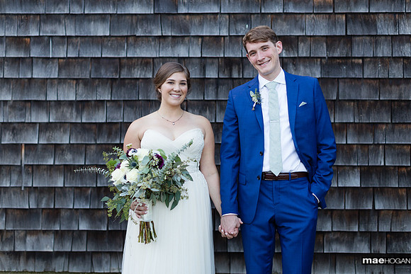 Bride and groom by barn at Castle Manor Inn